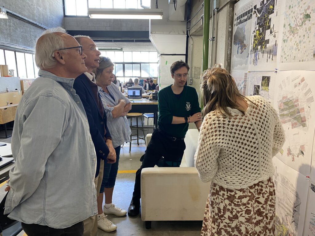Group from the architecture reunion looking at projects on the wall