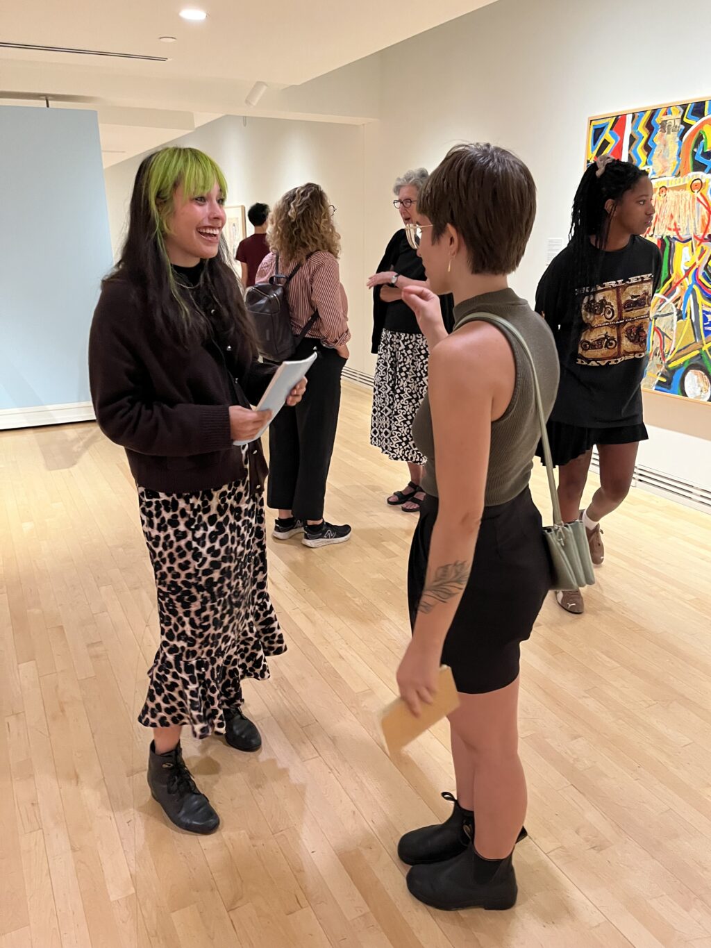Two people engaged in conversation at the Carleton University Art Gallery