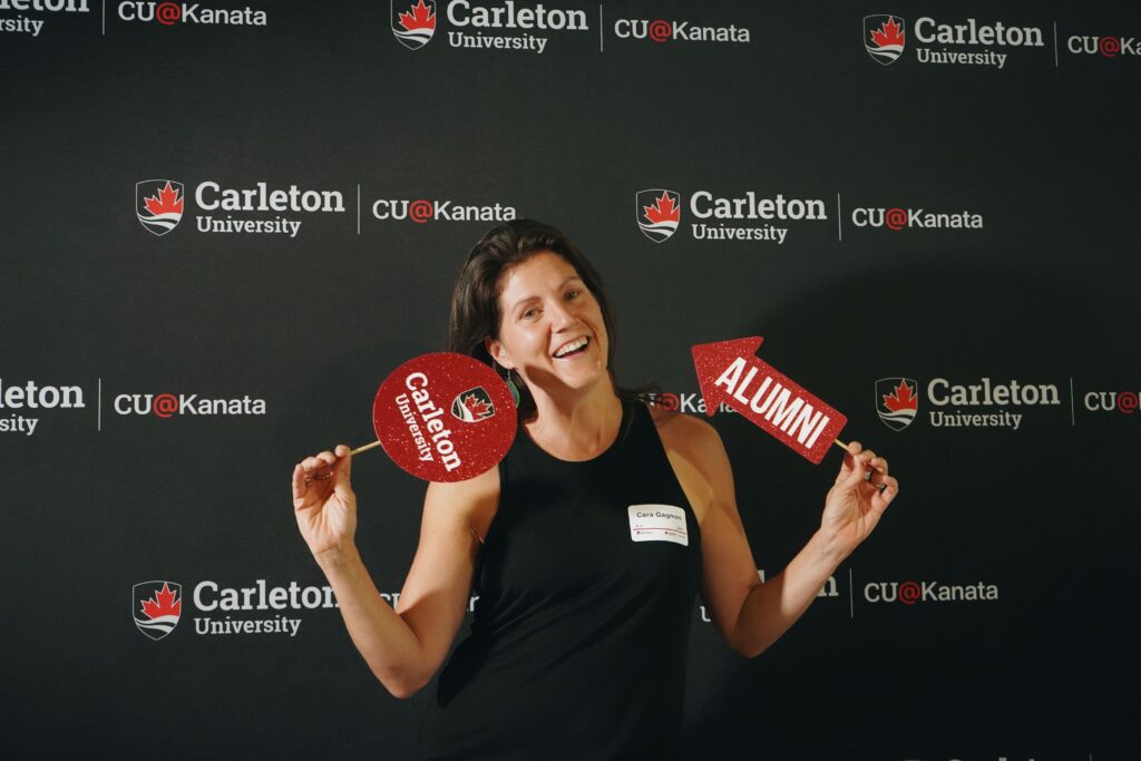 Person posing with alumni photobooth props