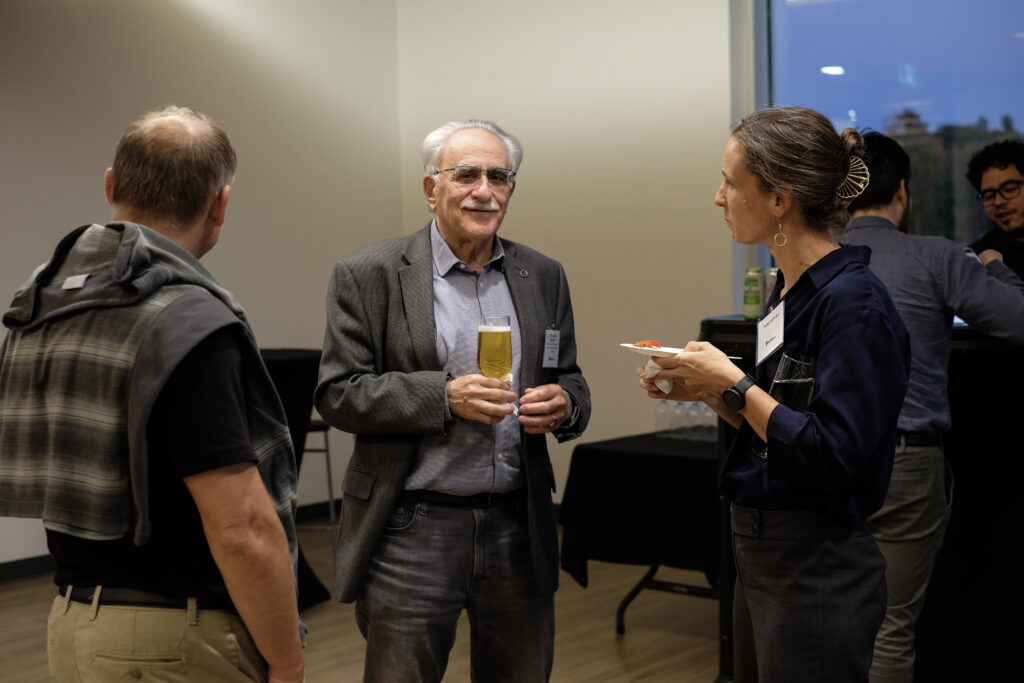 Three people engaged in conversation at the economics alumni reception