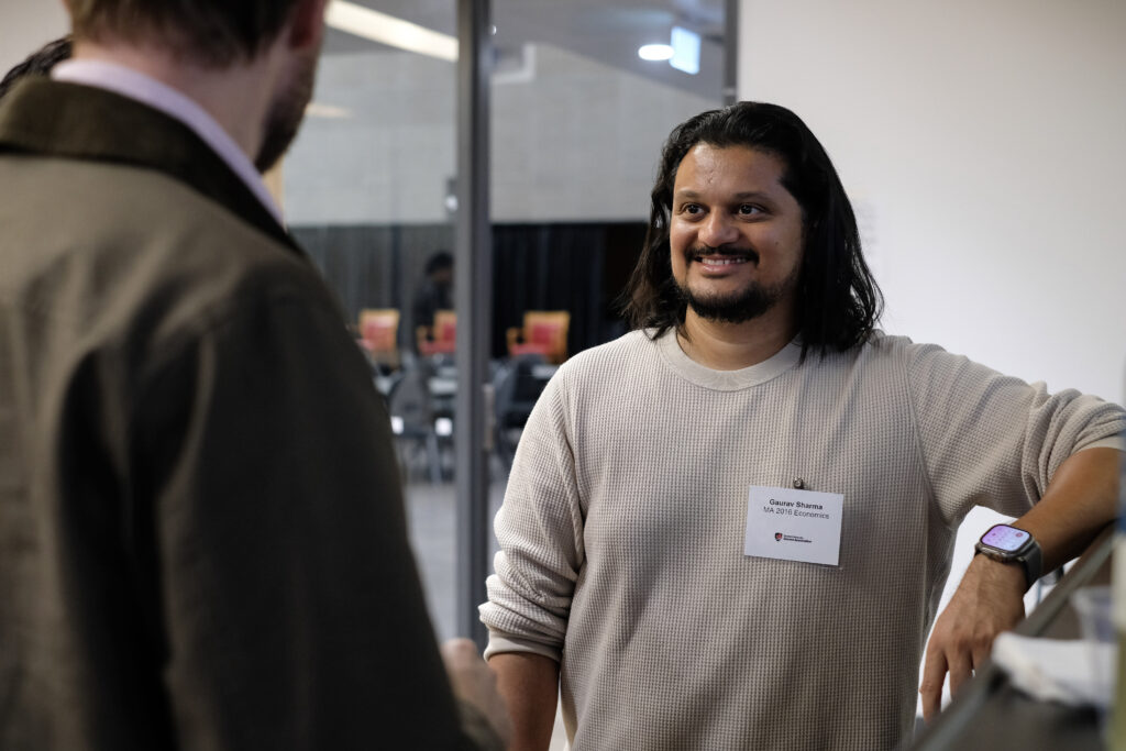 Alumni smiling and engaged in conversation at the economics alumni reception