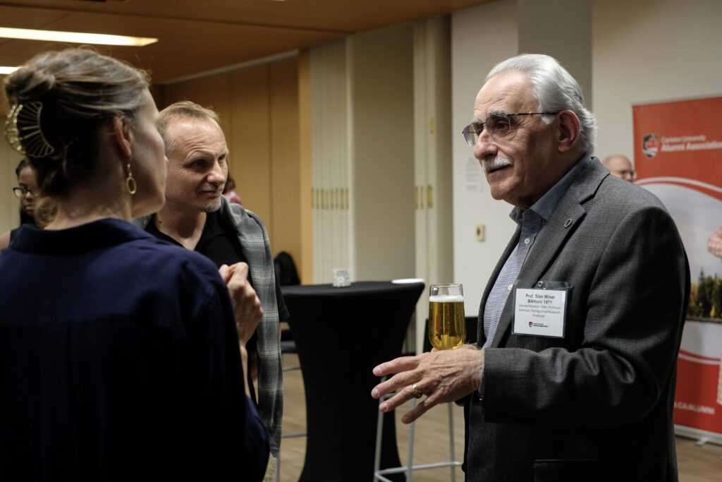 Three people engaged in conversation at the economics alumni reception