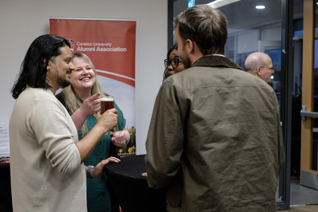 Group of people smiling and laughing at the economics alumni reception