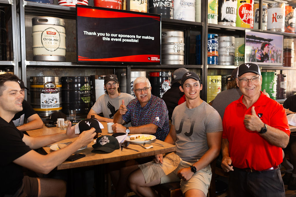 Photo of people smiling at a table at CRAFT Beer Market