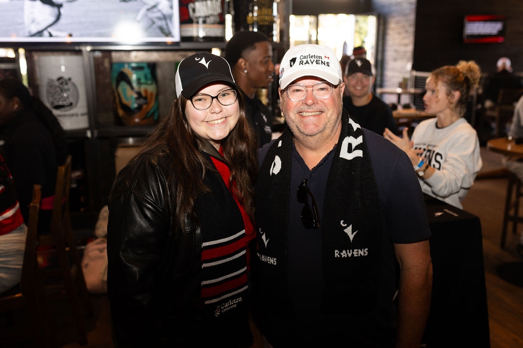 Two people in Ravens swag smiling at the camera