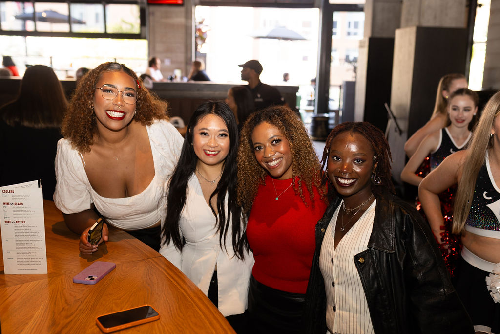 Group of four people smile at the camera
