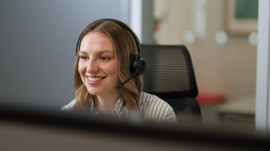 Person wearing a headset working at their desk