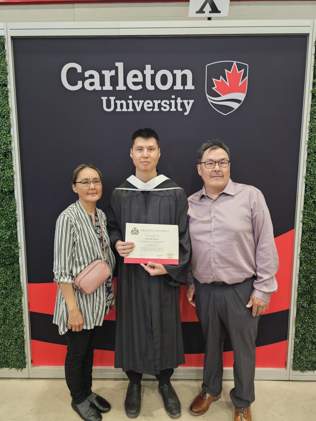 Brenand Mannik with his parents at convocation