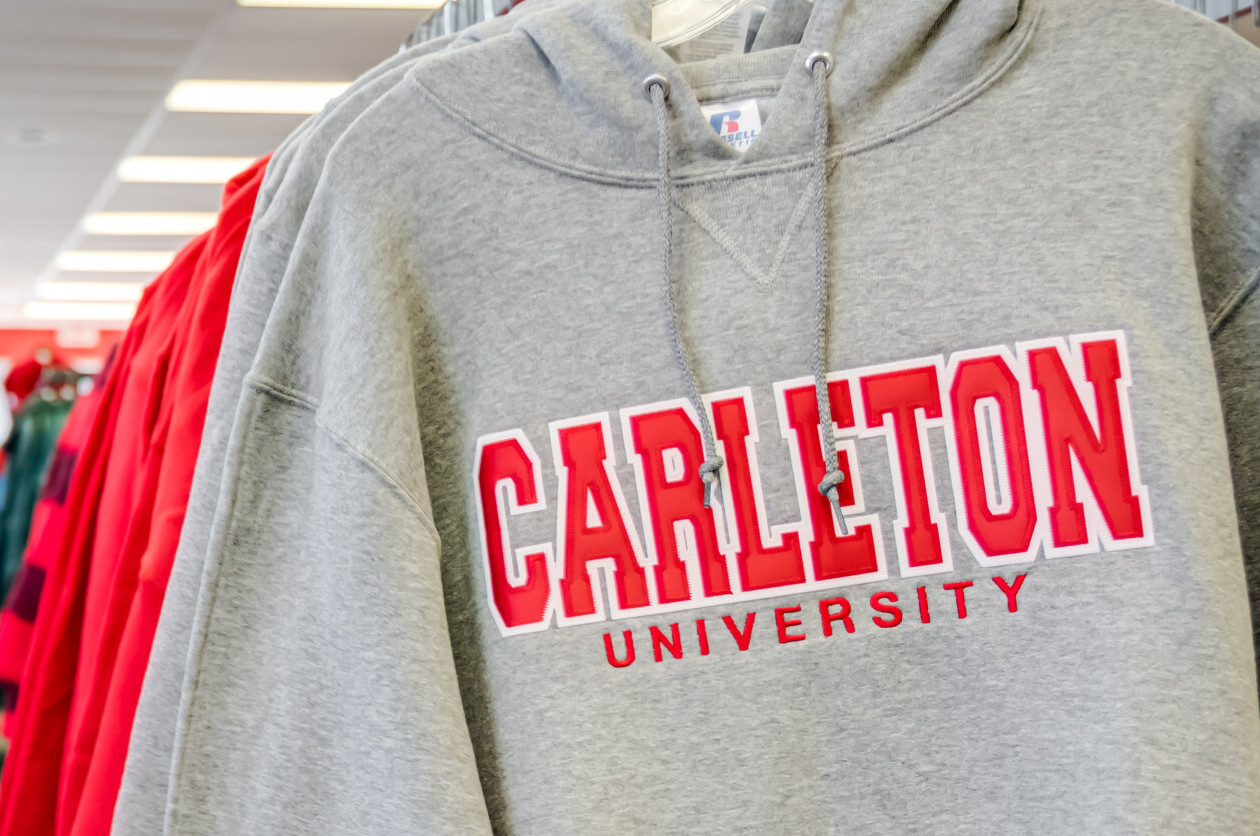 Carleton University branded hoodies hanging in a row at The Campus Store.