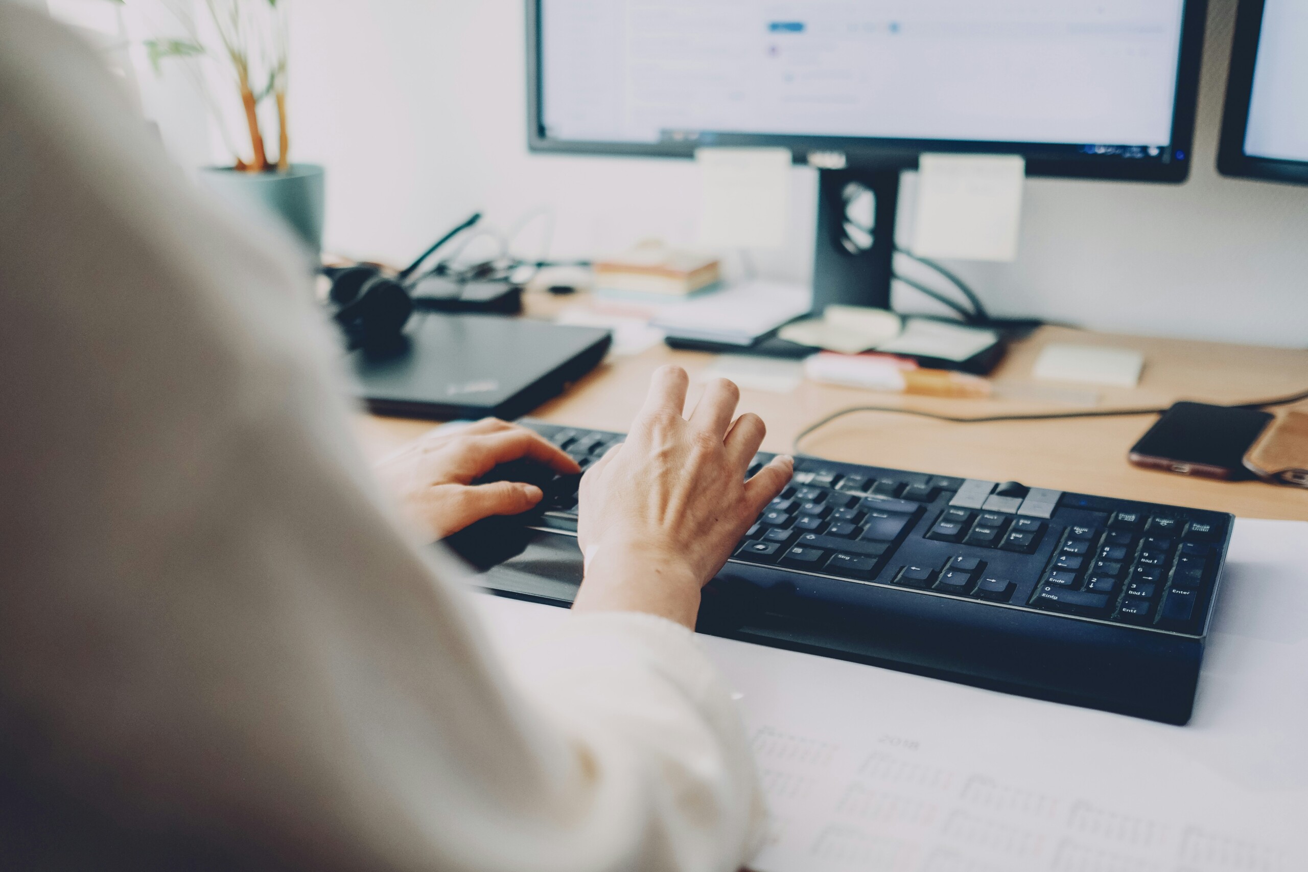 A woman typing on a keyboard. 