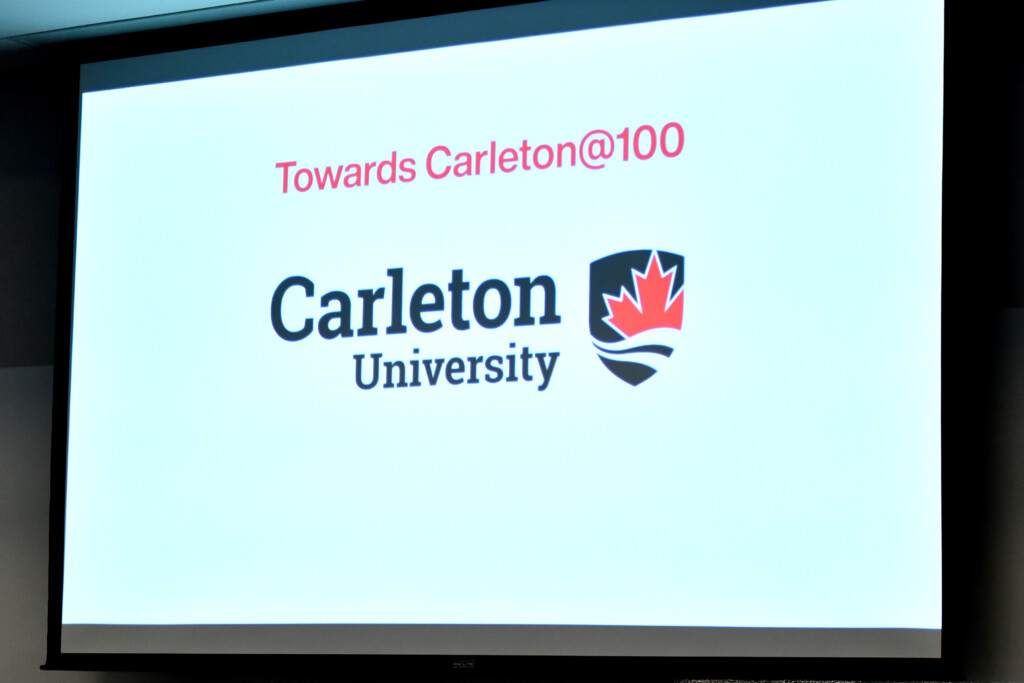 a photo of a white screen with the text "Towards Carleton@100" on it, with the Carleton University logo below.