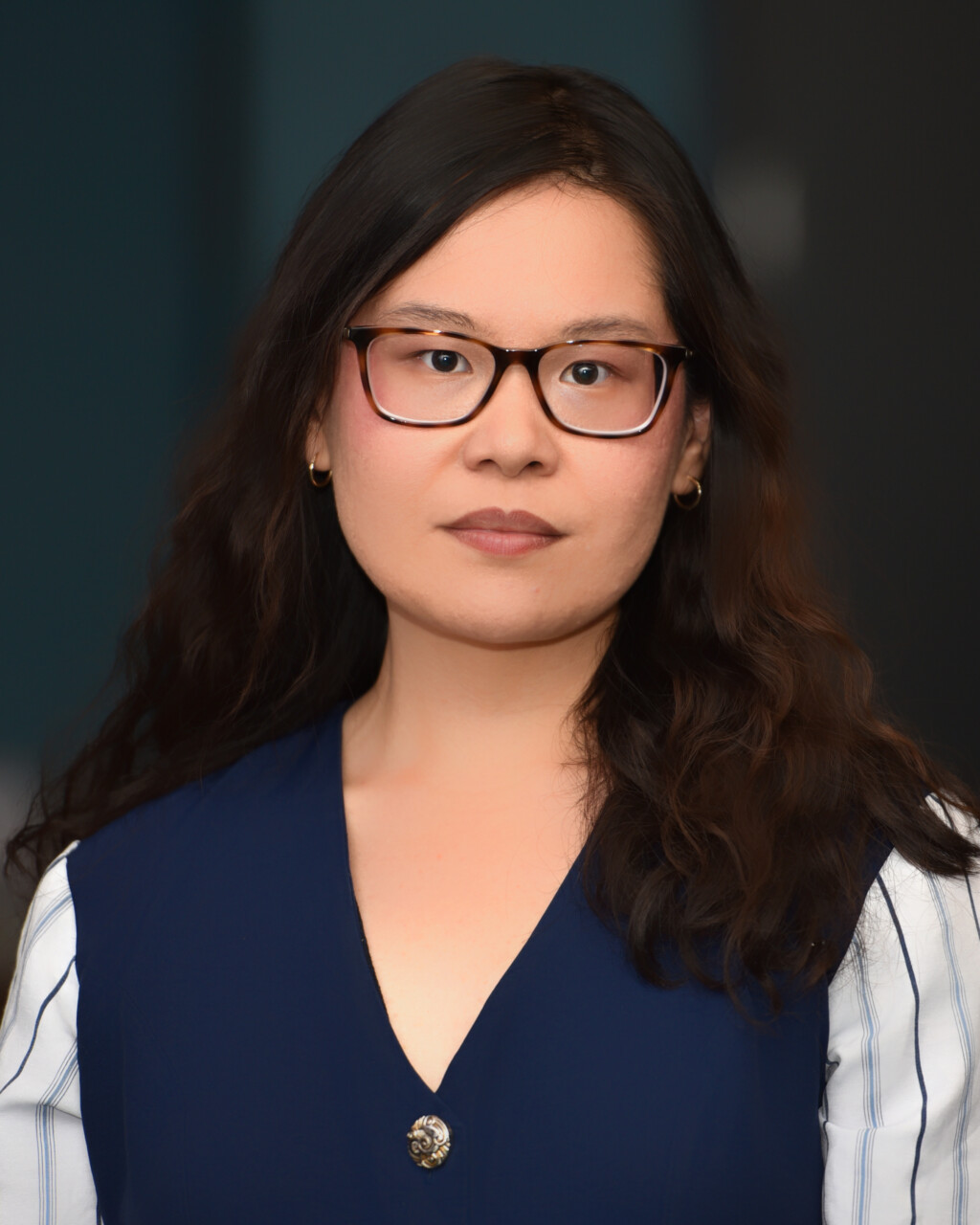 a portrait style photo of a woman with dark hair and glasses.