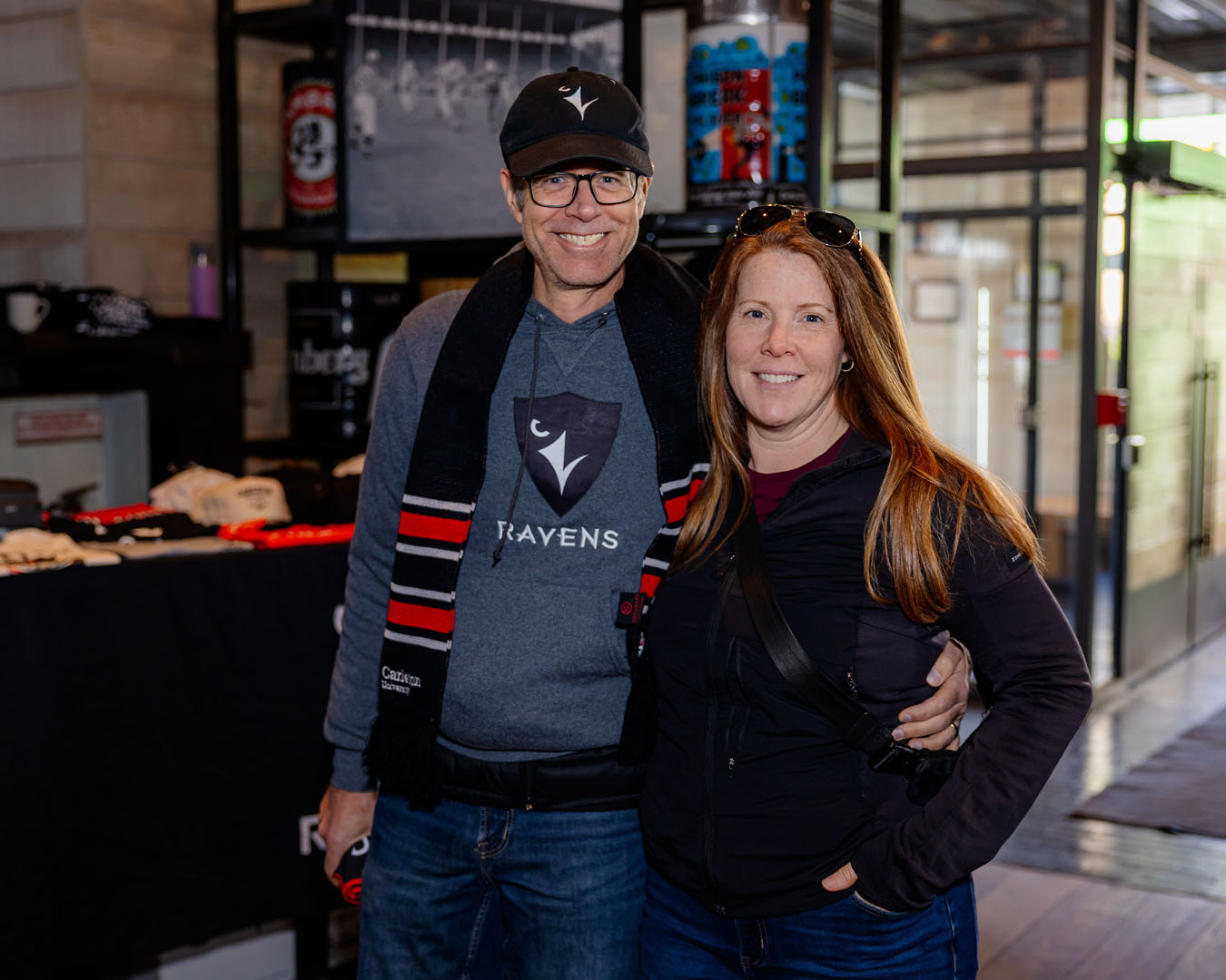 Two people smile for a photo at the entrance of CRAFT Beer Market