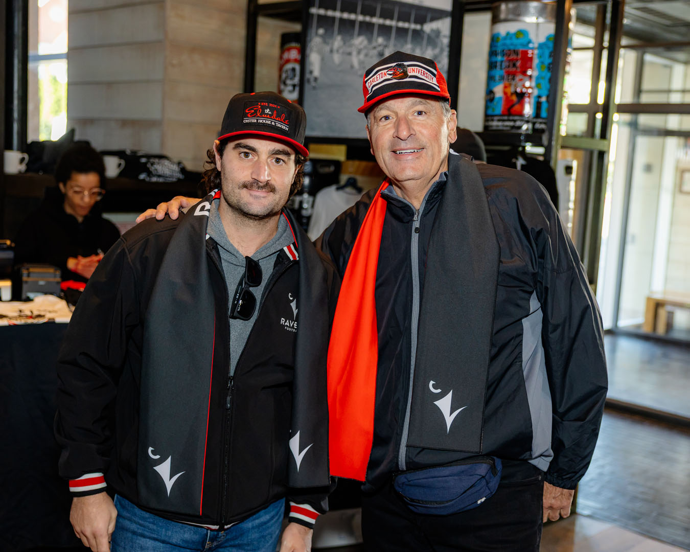 Two people wearing Ravens scarves smile for a photo