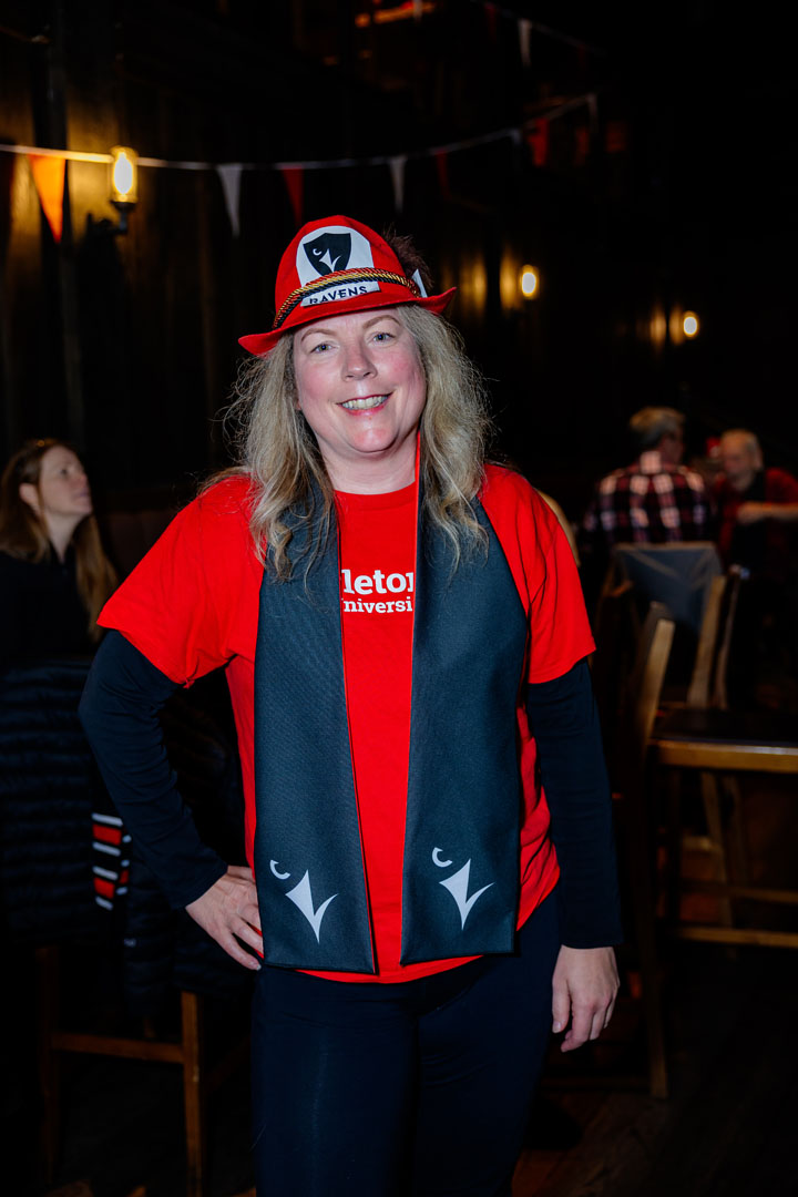 Person wearing Ravens gear smiles for a photo