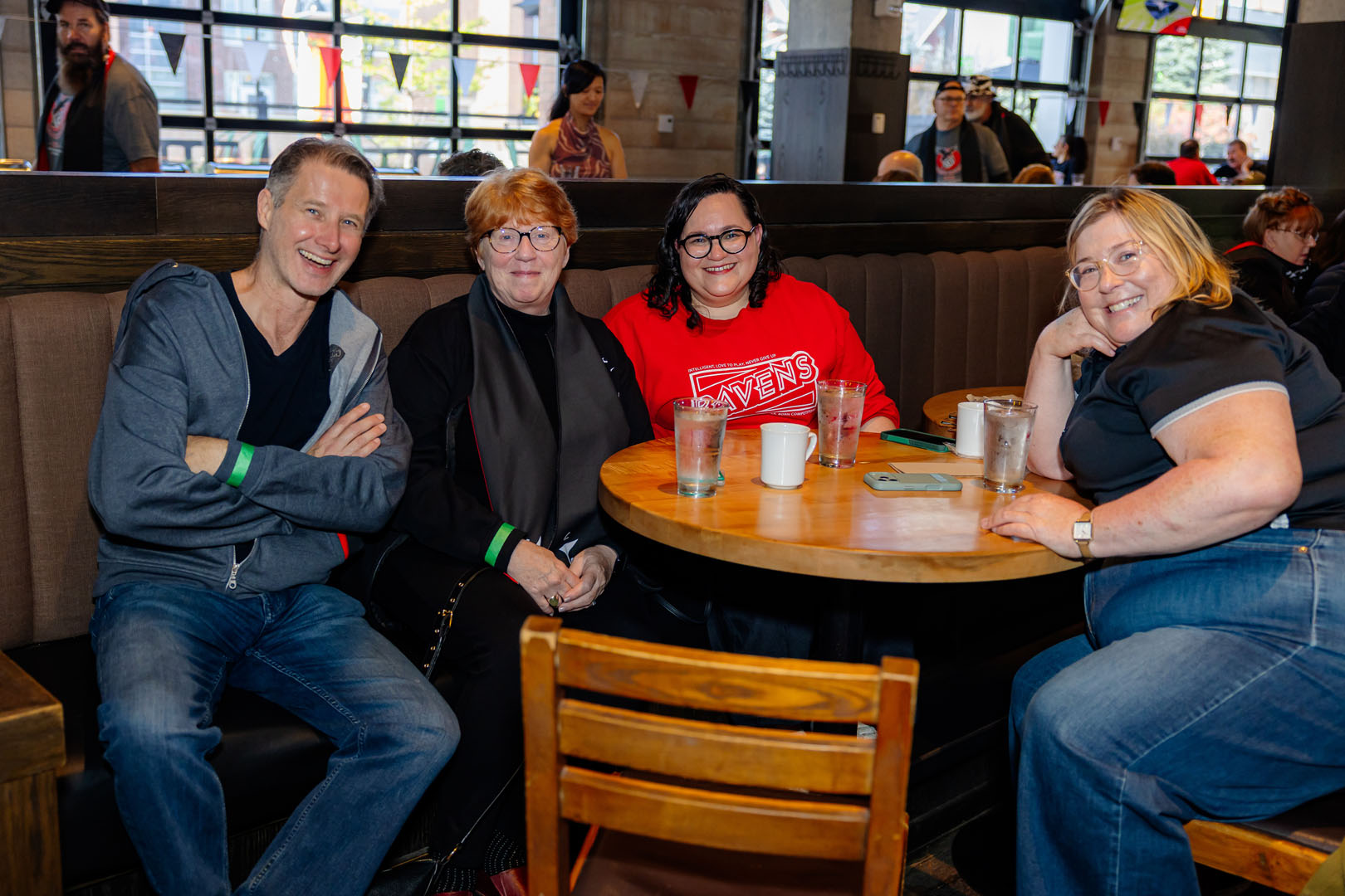 Four people smile, sitting around a table together