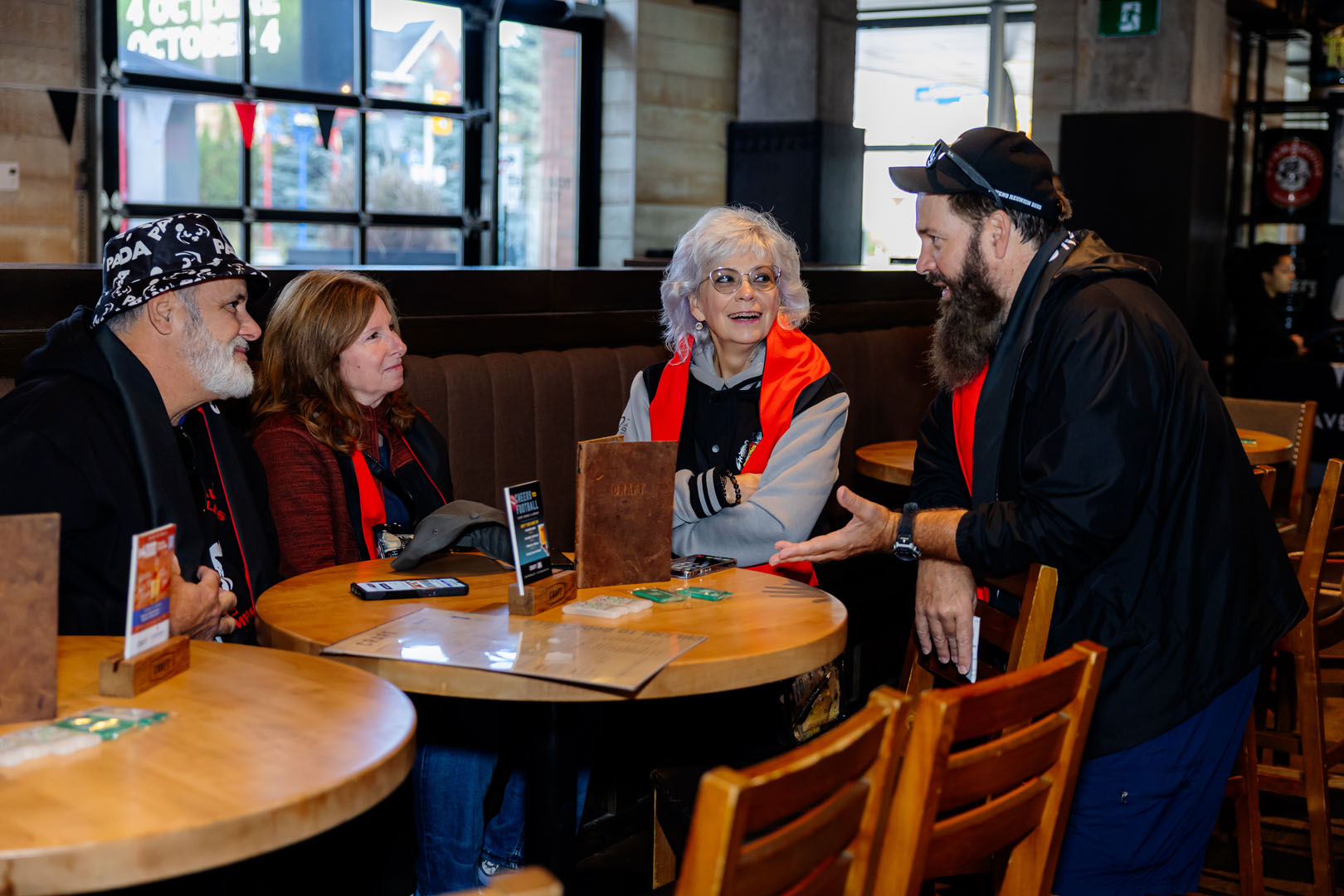 Four people smiling and talking at the Pancaker Breakfast.