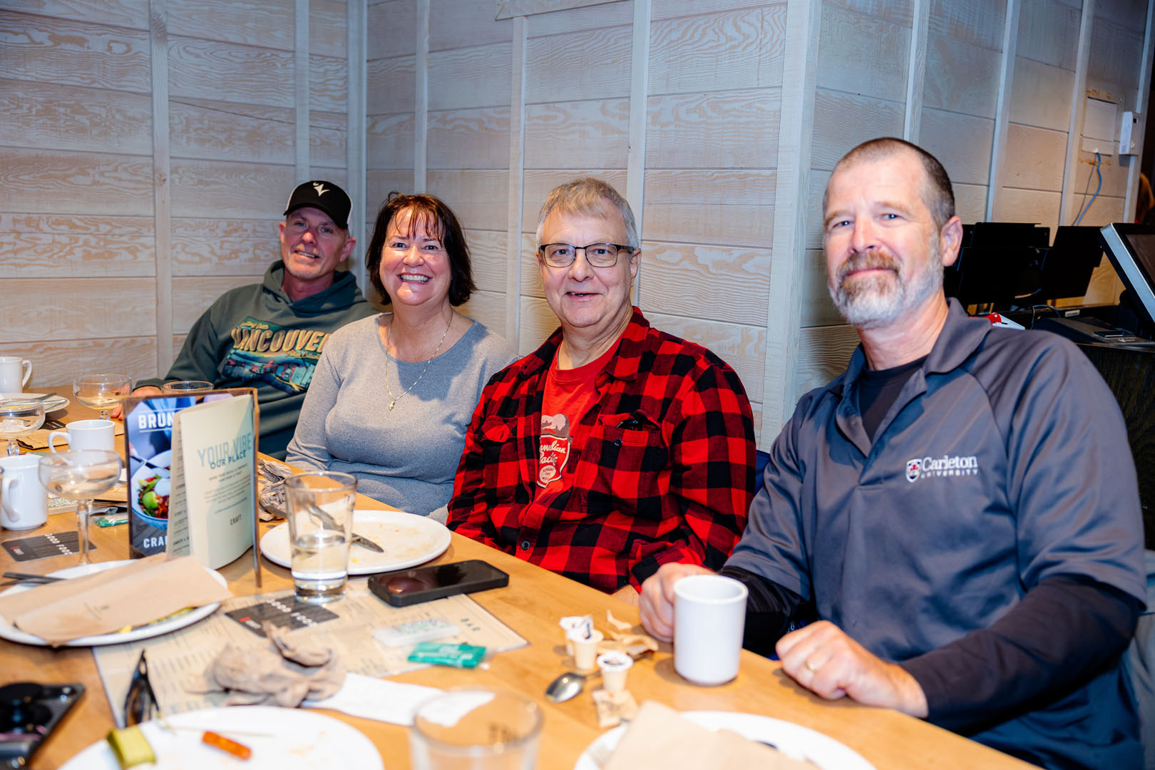 Four people sitting together smiling at the Pancaker Breakfast