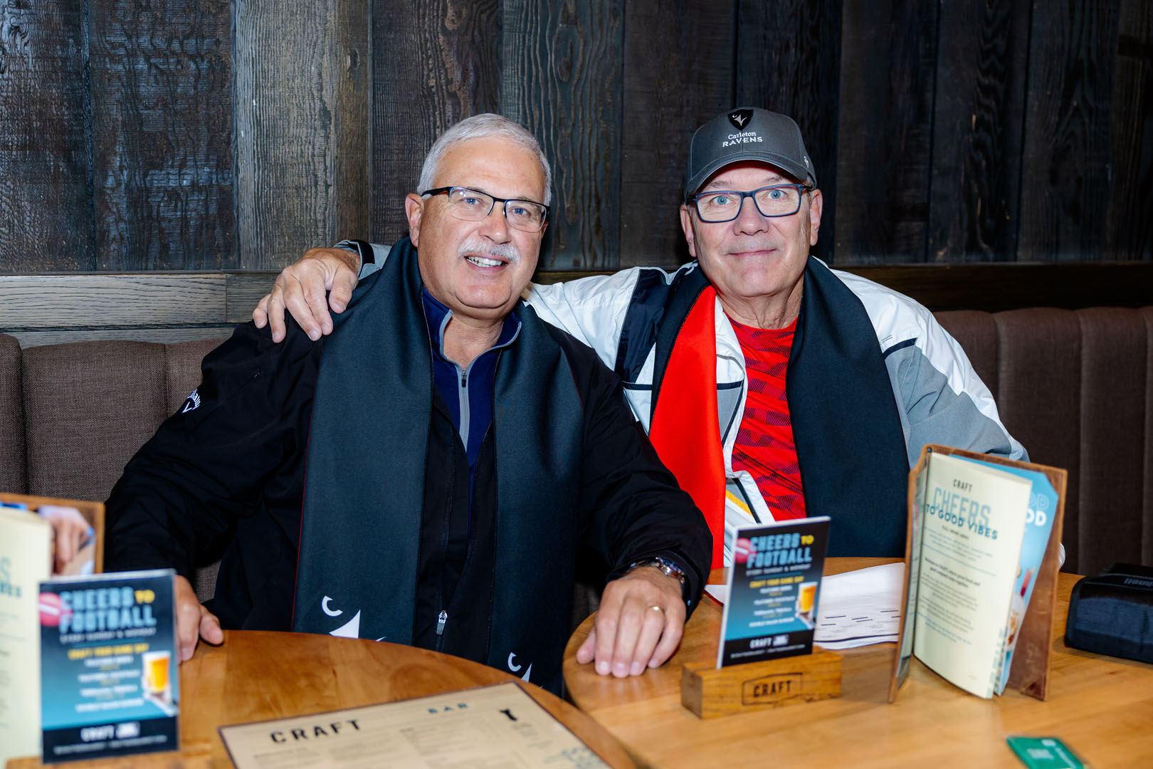 Two people sit, smiling at the Pancaker Breakfast