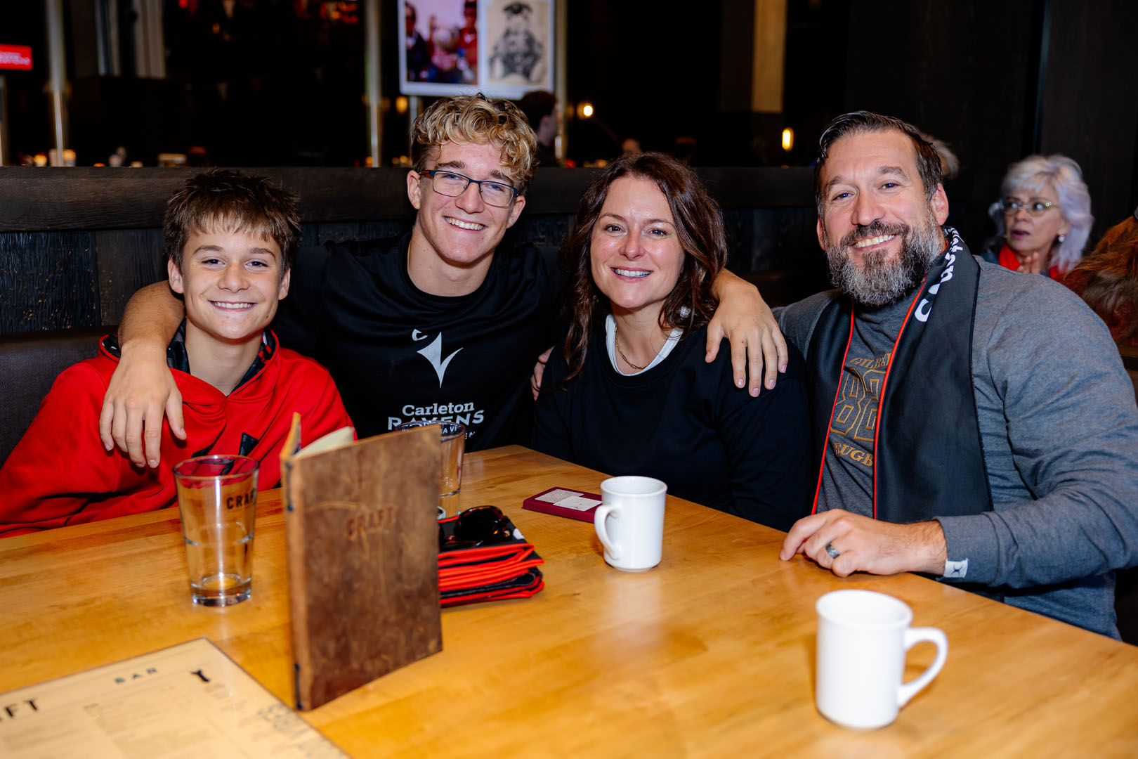 Four people sit around a table smiling at the Pancaker breakfast