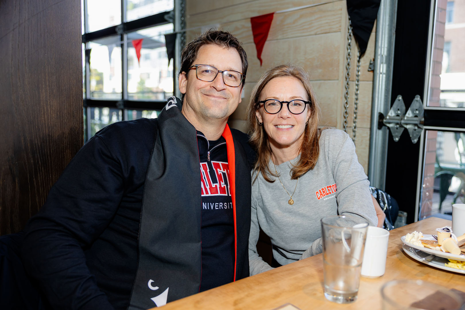 Two people smile seated at a table at the Pancaker Breakfast