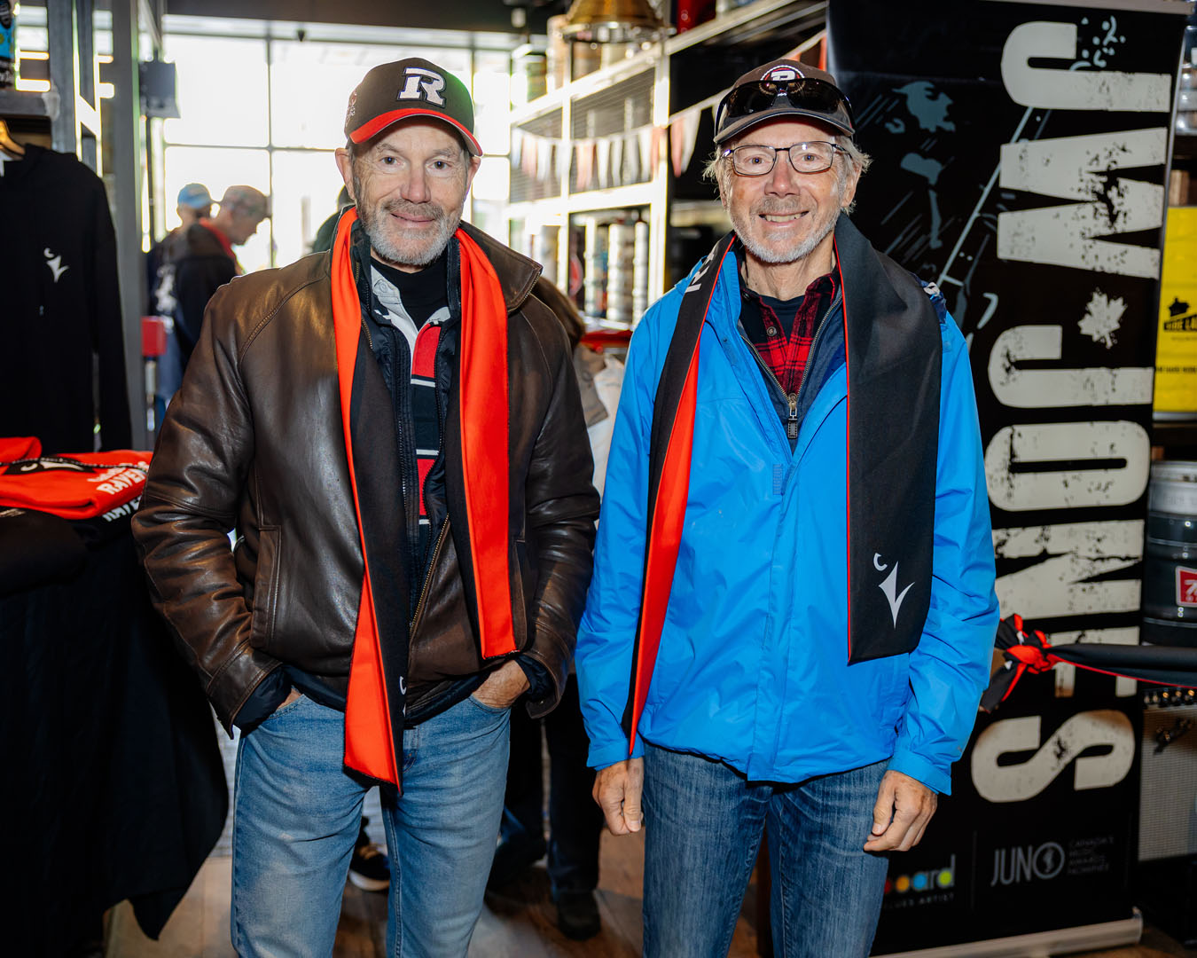 Two people smile wearing Ravens scarves