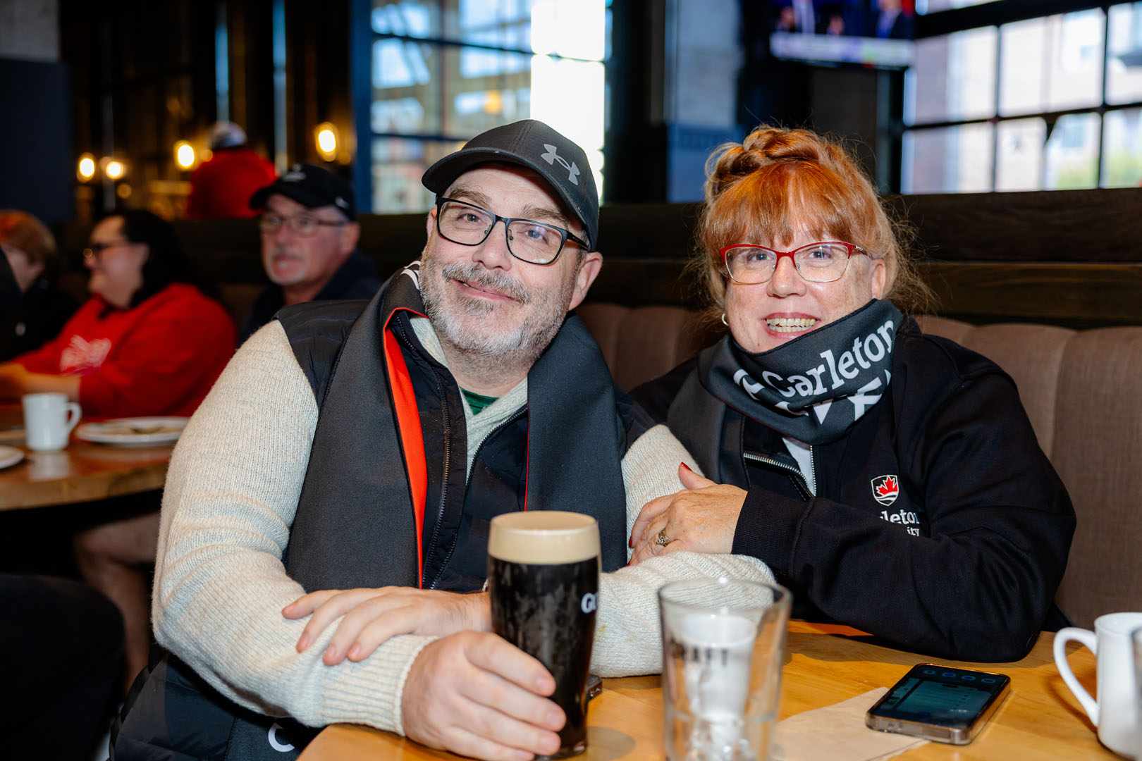 Two people sit, smiling at the Pancaker breakfast.