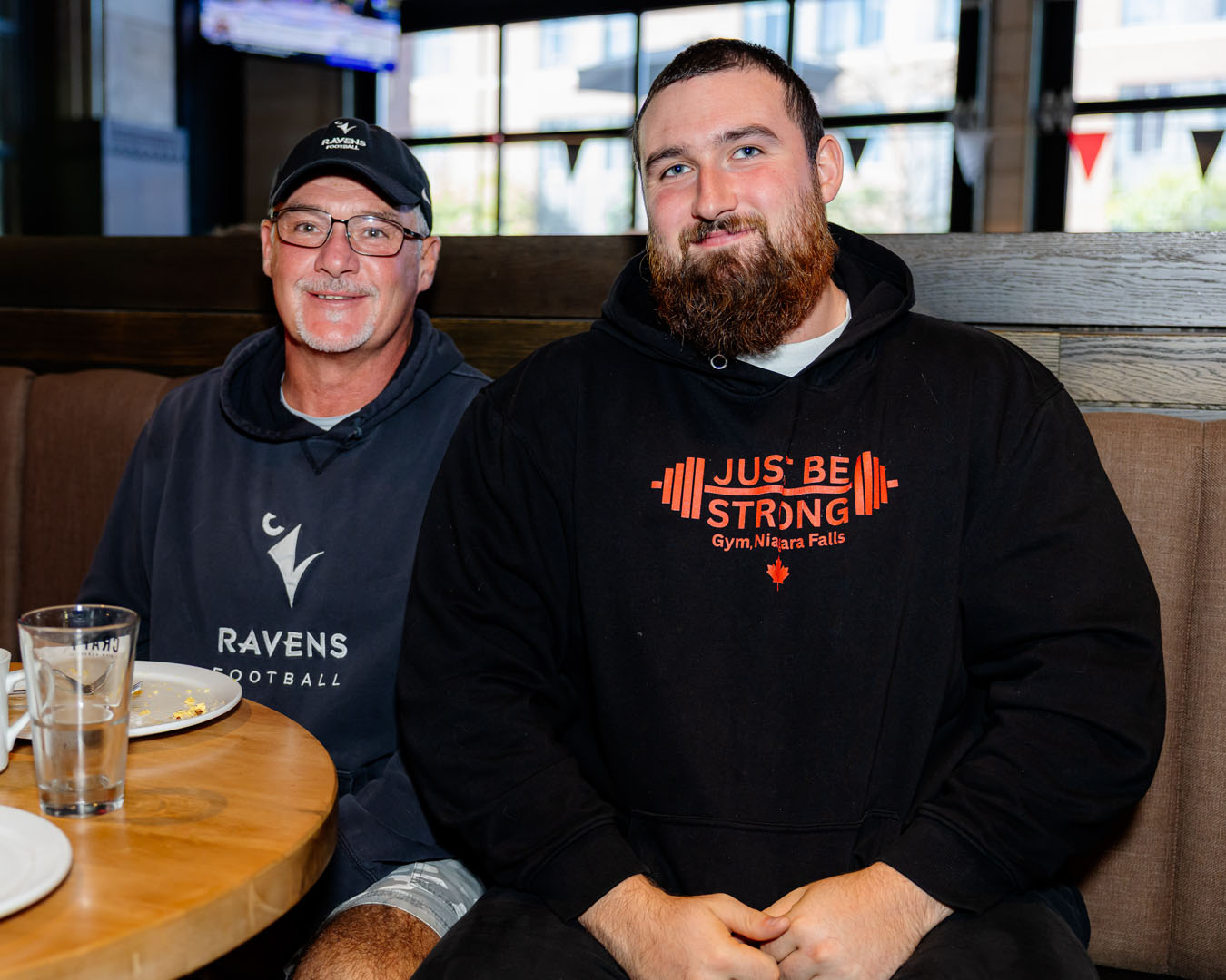 Two people sit, smiling at the Pancaker breakfast