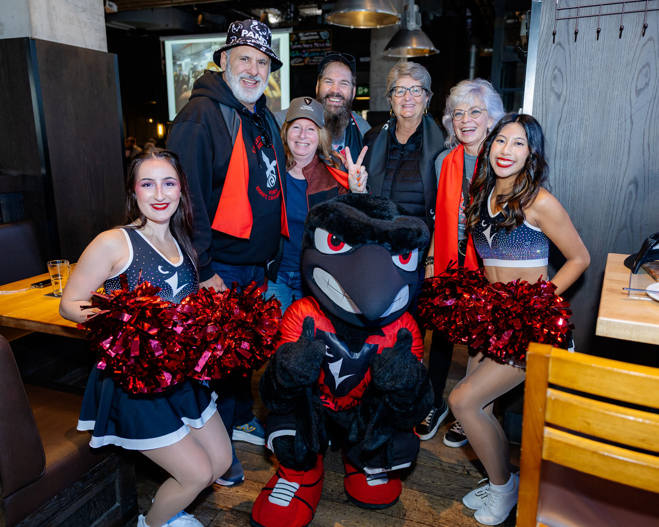 Five guests, Rodney, and two members of Ravens Rhythm smile for a photo